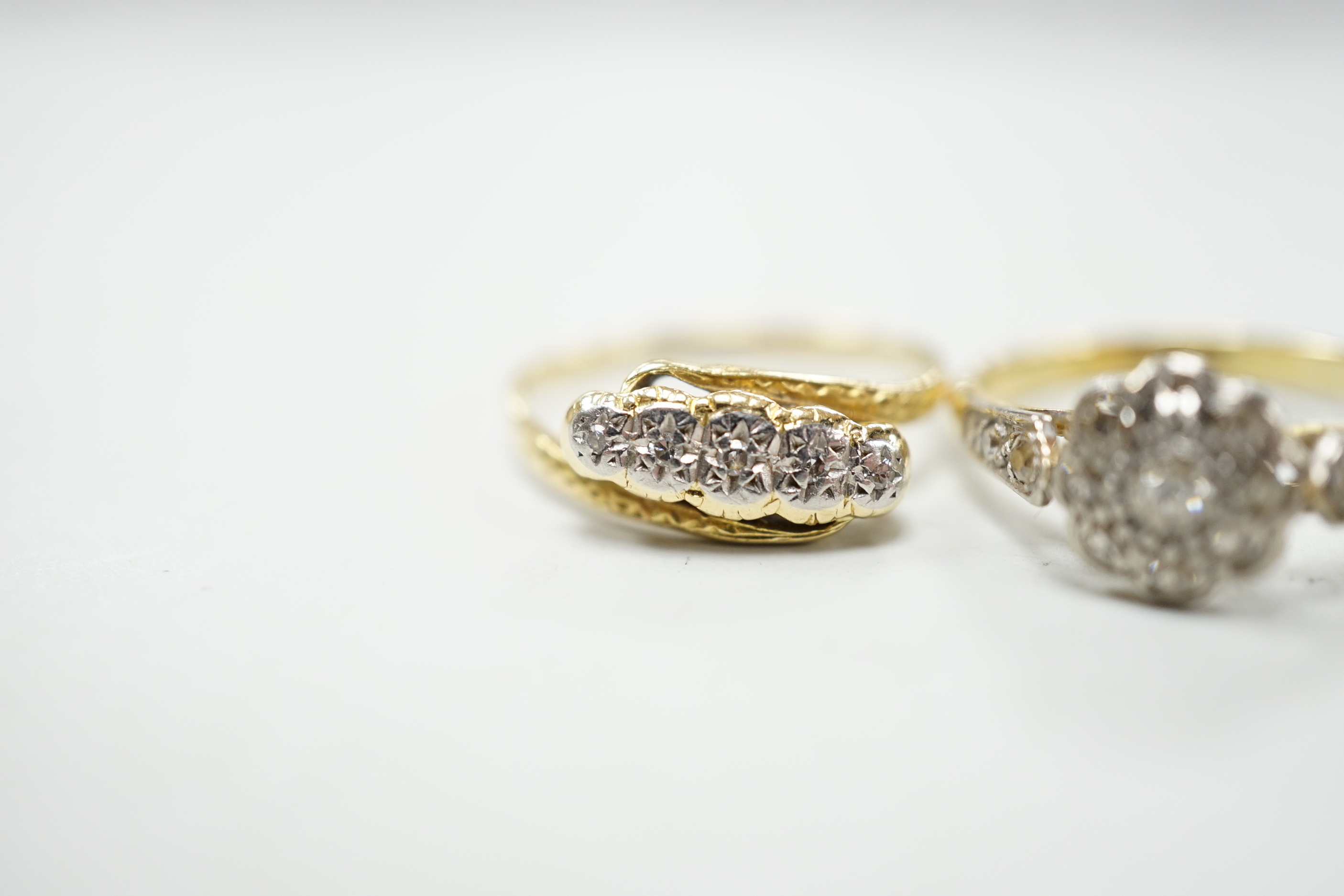 Three assorted 18ct and diamond cluster set rings including a late Victorian five stone diamond chip half hoop, gross weight 7.9 grams.